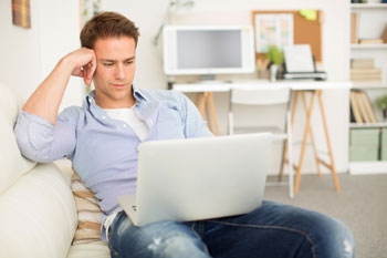 Student mit Laptop auf dem Schoß