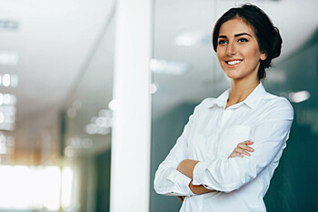 junge Psychologin mit weißer Bluse lächelt und schaut gen Himmel