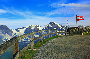 Ein Panoramabild der Alpen mit oesterreichischer Flagge