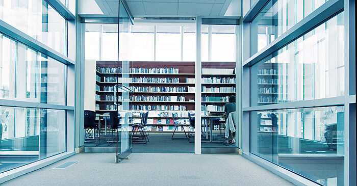 Der gläserne Eingangsbereich einer Bibliothek mit offener Glastür