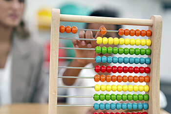 Kind und Psychologin benutzen einen Rechenschieber