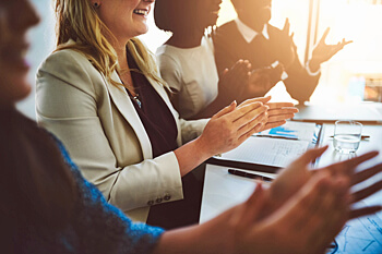 Wirtschaftspsychologen sitzen in Meeting und klatschen in die Hände